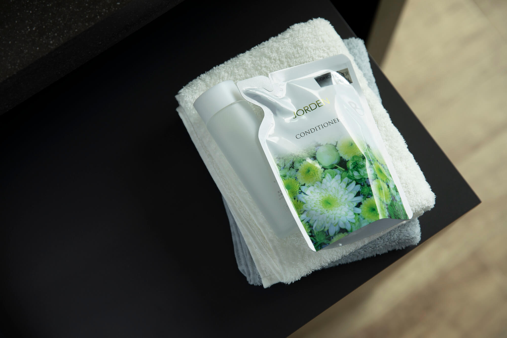 Flowpack NT is laying next to a bottle on top of towels in the kitchen counter.
