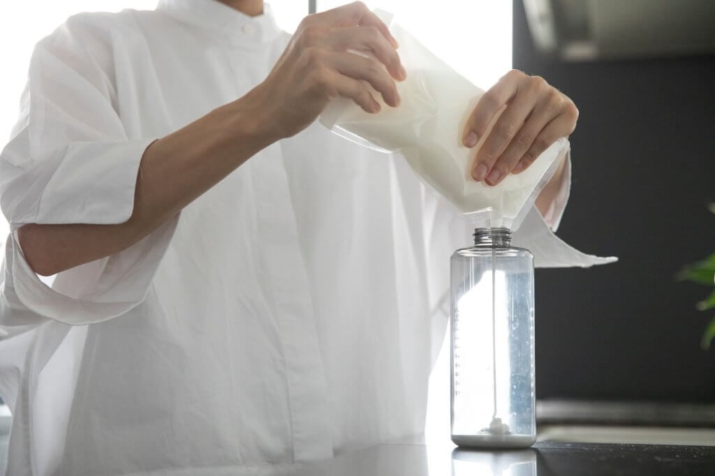 A person is refilling a bottle from Flowpack NT